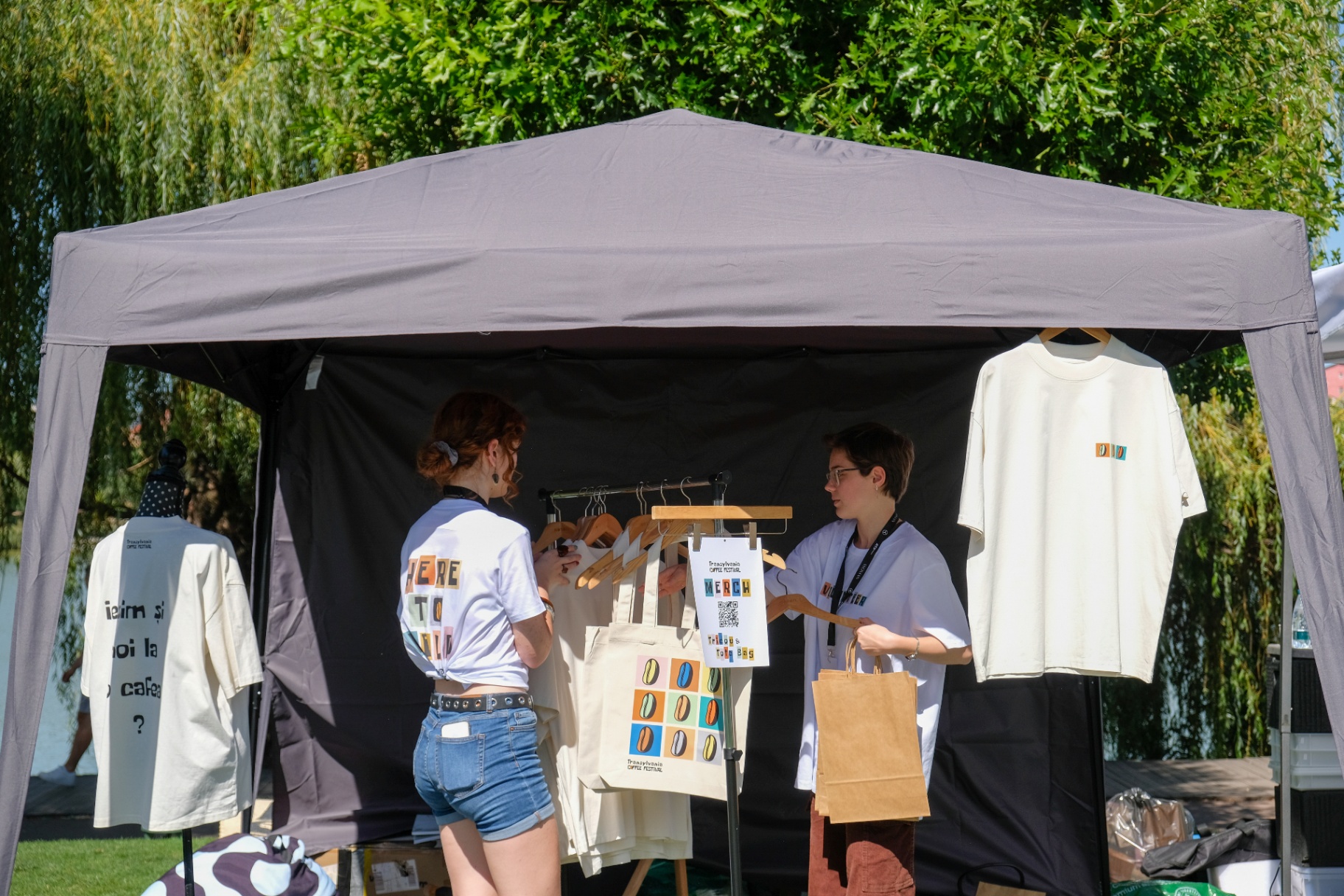 Festival merchandise stand with shirts and tote bags