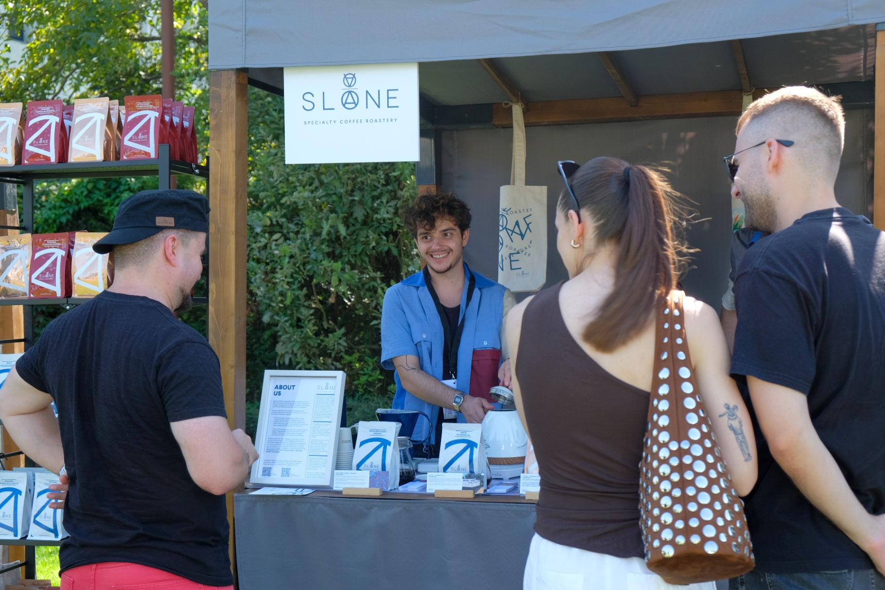 Guests chatting with a roaster at a specialty coffee booth